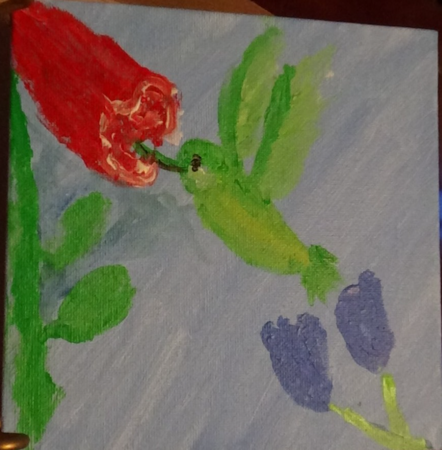 Hummingbird eating the nectar of a red flower
